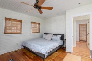 a bed in a room with a ceiling fan at Longboard House in Tybee Island