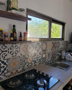 kuchnia z kuchenką, umywalką i oknem w obiekcie Departamento cómodo y hermoso a mts de la playa w mieście San Crisanto