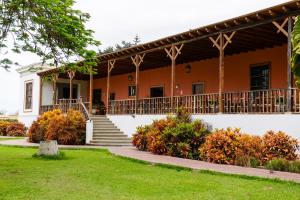an orange building with a porch and stairs at Casa Hacienda San Jose in Chincha Alta