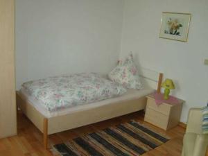 Dormitorio pequeño con cama y mesa en Pension Am Limespfad, en Hesseneck