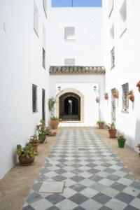 un pasillo de un edificio blanco con suelo a cuadros en Apartamento Casa de la Parra, en Vejer de la Frontera