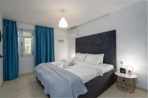 1 dormitorio con 1 cama grande y cortinas azules en Camping Stolos, en Limín Litochórou