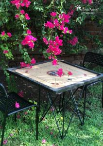 a picnic table with pink flowers on top of it at Dreamland by Nature's Abode® Villas in Ahmedabad