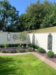 a white building with a yard with flowers and plants at Robin Hill Bed and Breakfast in Curracloe