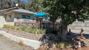 uma casa com uma cerca e um guarda-chuva azul em Chili Bar Casita em Placerville