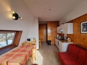 Saint-Michel-de-ChaillolにあるAppartement Saint-Michel-de-Chaillol, 2 pièces, 5 personnes - FR-1-393-6の小さなキッチン(赤いソファ付)