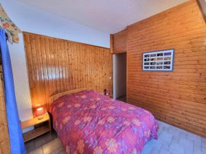 a bedroom with a bed and a wooden wall at Appartement Saint-Michel-de-Chaillol, 2 pièces, 5 personnes - FR-1-393-6 in Saint-Michel-de-Chaillol