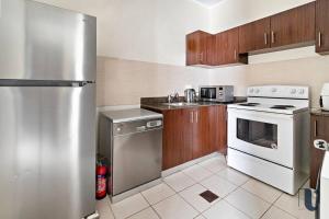 a kitchen with a stainless steel refrigerator and a dishwasher at Nazeel - TownHouse Al-waha in King Abdullah Economic City