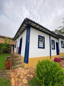 une petite maison blanche et bleue avec des ornements bleus dans l'établissement Canto do Bichinho, à Prados