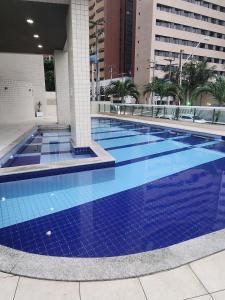 una piscina con azulejos azules en un edificio en Condomínio Terraço do Atlântico, en Fortaleza