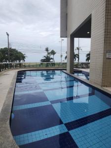 una piscina en un edificio con suelo de baldosa en Condomínio Terraço do Atlântico, en Fortaleza