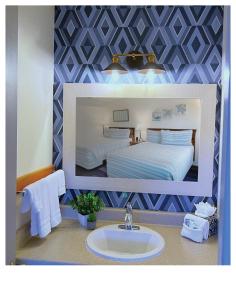 una imagen de una habitación de hotel con cama y lavabo en Surf & Sand Inn, en Pacific City