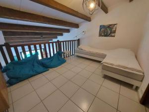 Habitación pequeña con cama y suelo de baldosa. en Villa Marseillan, 5 pièces, 10 personnes - FR-1-326-392, en Marseillan