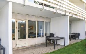 a patio with a table and a dining table at One-Bedroom Apartment In Ringkobing in Ringkøbing