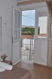 a bedroom with a door open to a balcony at Maroulitsas Sea Esta 2 in Haraki