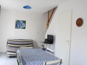 Schlafzimmer mit einem Bett, einem Schreibtisch und einem TV in der Unterkunft Maison Marseillan-Plage, 3 pièces, 5 personnes - FR-1-326-448 in Marseillan