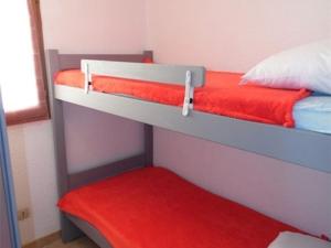1 Schlafzimmer mit 2 Etagenbetten und einer roten Decke in der Unterkunft Studio Marseillan-Plage, 1 pièce, 6 personnes - FR-1-326-452 in Marseillan