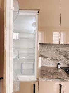an empty refrigerator with its door open in a kitchen at Sodu apartment in Kaunas