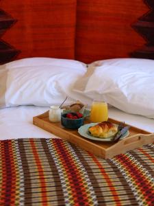 a tray of food on a bed with a plate of food at House Prada in Bragança