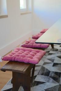a row of purple seats sitting on a wooden bench at House Prada in Bragança