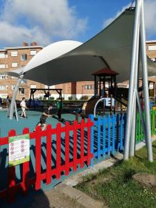 a playground with a red and blue fence at APARTAMENTO LA GRANJA EN GAMA(next to Santoña) in Gama
