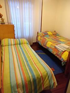 two beds sitting next to each other in a bedroom at APARTAMENTO LA GRANJA EN GAMA(next to Santoña) in Gama
