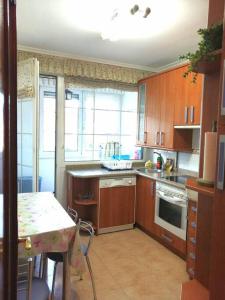 a kitchen with wooden cabinets and a table and a table and a tableablish at APARTAMENTO LA GRANJA EN GAMA(next to Santoña) in Gama