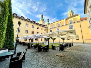 un patio con mesas y sombrillas frente a un edificio en Nové Adalbertinum en Hradec Králové