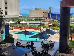 a view of a pool with tables and umbrellas at Condomínio Porto de Iracema in Fortaleza