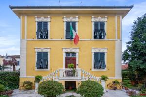 un edificio giallo con una bandiera di Villa San Donato B&B a Lucca