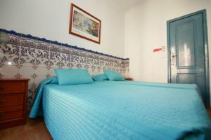 - une chambre avec un lit bleu et une couette bleue dans l'établissement Residencial Joao XXI, à Lisbonne