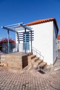 un edificio con una escalera junto a una acera de ladrillo en Cellorico de Sabores, en Celorico da Beira