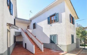 una casa con una escalera delante de ella en Pet Friendly Apartment In San Leonardo Di Cutro With Kitchen, en Le Castella