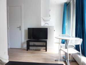 a living room with a television and a table at Eiffel Grenelle in Paris