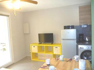 eine Küche mit einem Kühlschrank und einem TV auf dem Tisch in der Unterkunft Appartement Marseillan-Plage, 3 pièces, 5 personnes - FR-1-387-121 in Marseillan