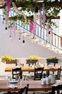 a dining room with tables and flowers hanging from the ceiling at Camping Stolos in Limín Litochórou