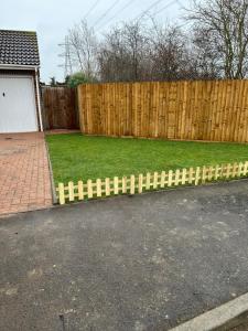 una cerca en un patio al lado de un patio trasero en Ofrise Homes, en Barking