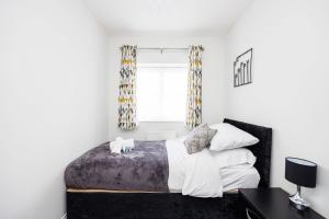 a bedroom with a bed and a window at Ofrise Homes in Barking