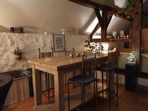 cocina con mesa de madera y sillas en O'pOzArt Guesthouse, en Durnal