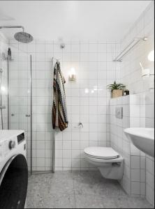 a white bathroom with a toilet and a sink at Spacious & stylish apartment in Oslo - Supercentral in Oslo