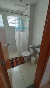 a bathroom with a toilet and a shower curtain at Lindo Apartamento perto da praia in Rio das Ostras