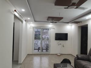 a living room with a couch and a flat screen tv at Hillstay Rushikonda in Visakhapatnam