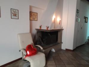 sala de estar con chimenea y silla con velas en A casa di Grazia en Vitorchiano