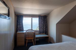 a bedroom with a desk and a chair and a window at Terimore Lodging by the Sea in Tillamook