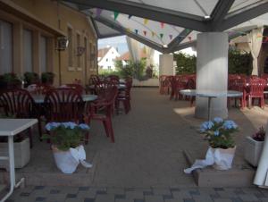 an empty patio with tables and chairs and flowers at Hotel Restaurant Schiff in Möhlin