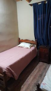 1 dormitorio con cama y cortina azul en Cabaña la Encantada en Humahuaca