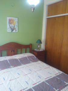 een slaapkamer met een bed en een houten deur bij Las dos A in Chascomús