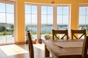 a dining room with a table and views of the water at Agroturystyka nad Wielkim Szelągiem in Stare Jabłonki
