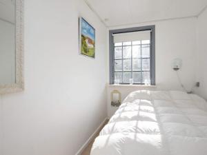 Un dormitorio blanco con una gran cama blanca. en Holiday home Hjørring XXXII, en Hjørring