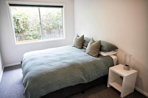a bedroom with a large bed with a window at LONSDALE ON GLANEUSE in Point Lonsdale